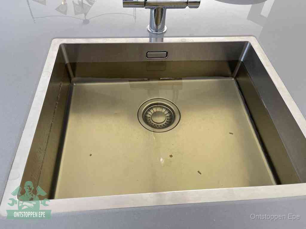 Een RVS spoelbak met stilstaand water dat niet wegloopt, een van de eerste signalen van een beginnende verstopping in Epe