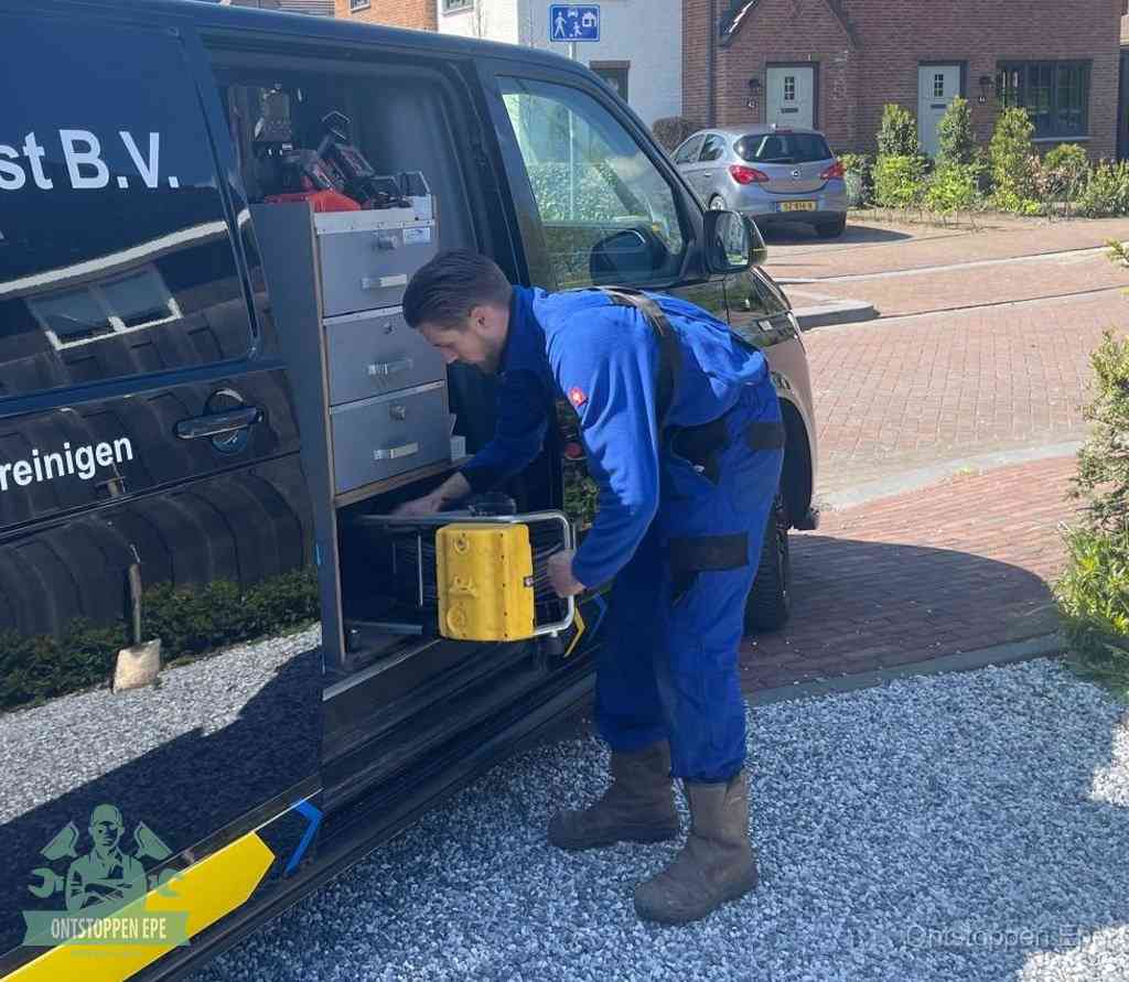 Een monteur pakt gereedschap uit de bedrijfsbus, het moment om een professionele ontstoppingsdienst in te schakelen in Epe